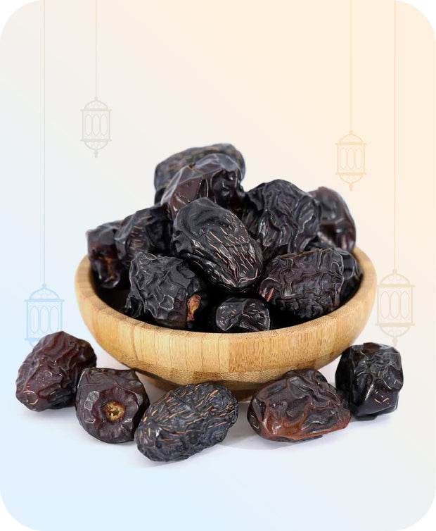 Wooden bowl overflowing with dark Ajwa dates with additional dates scattered around on a pastel gradient background with lanterns.