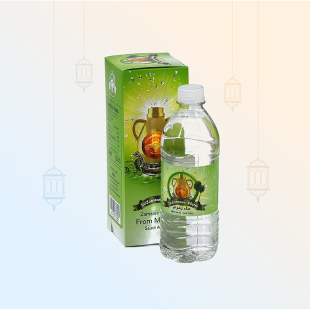 Clear plastic bottle of Zamzam water next to its green cardboard box featuring an Islamic motif and imagery of a traditional pitcher.